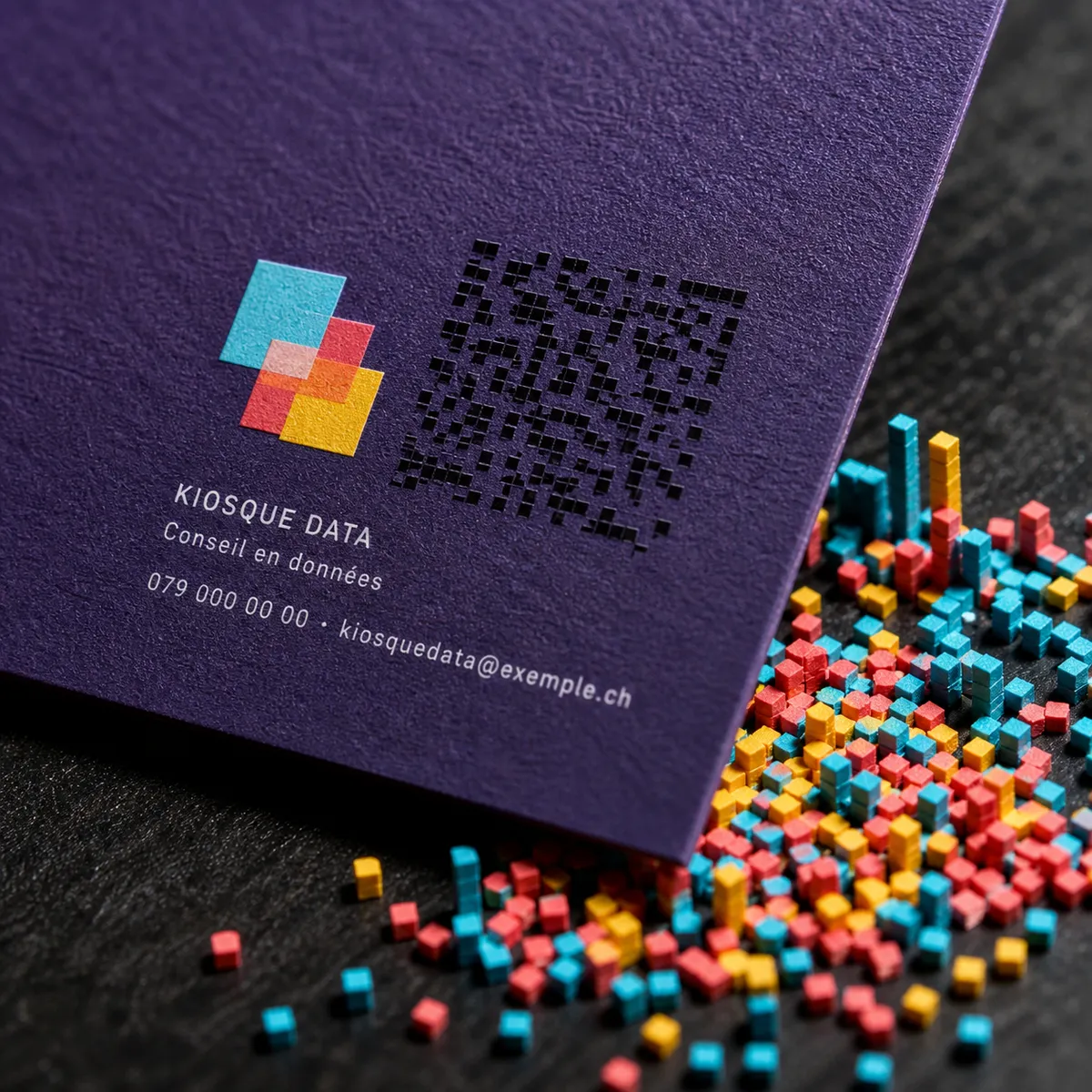 Gros plan sur le coin d'une carte de visite violette avec petit logo géométrique et motif de QR code - détail typographique moderne